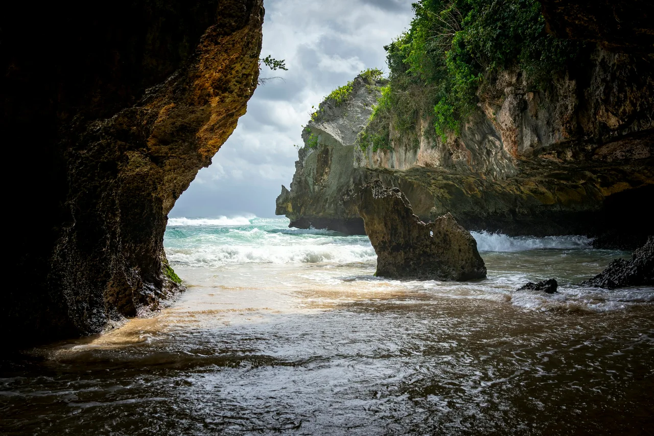 The ocean framed by a rocky coastal cave