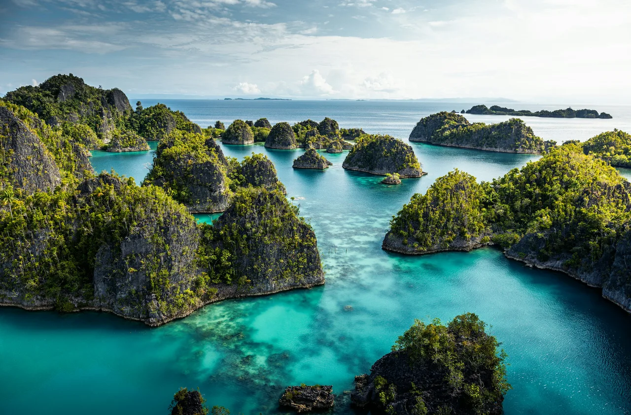 Limestone islands surrounded by clear turquoise water in Raja Ampat
