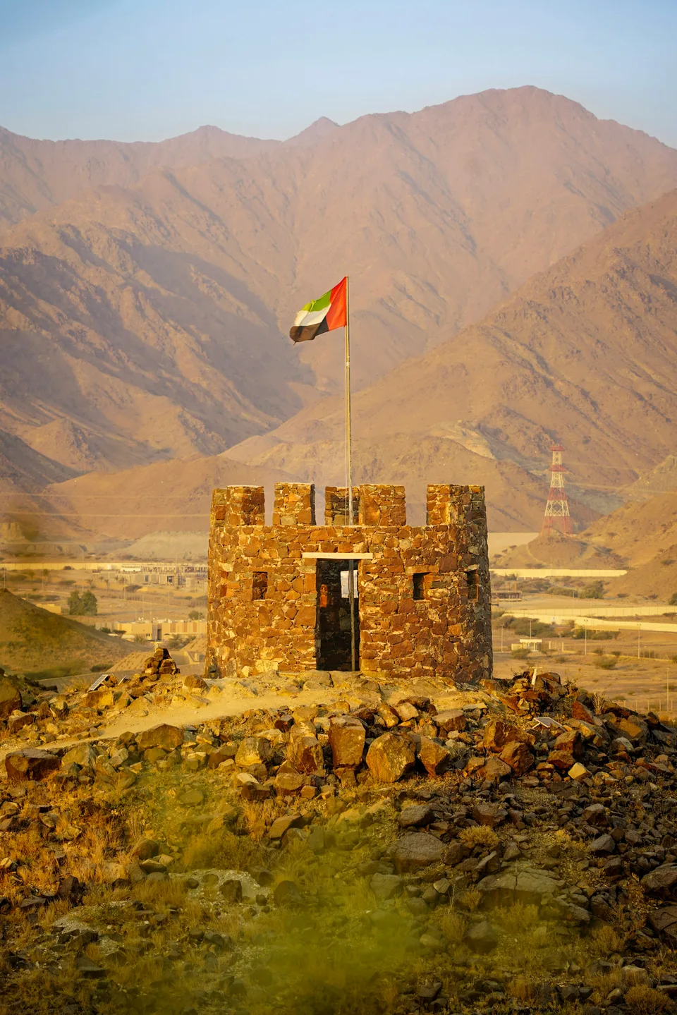Stone watchtower with rugged mountains in the background